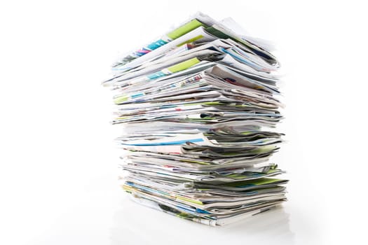 Stack of waste paper, old magazines, newspapers and leaflets for recycling isolated on white