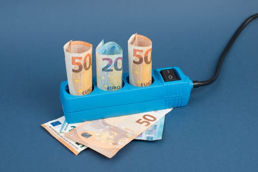 Euro banknotes in a power outlet, rising prices, expensive green electricity, Germany