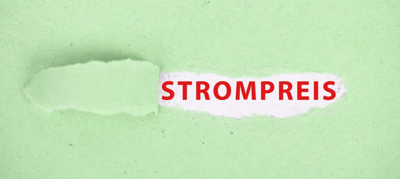 The words price for electricity are standing in german language on a torn paper in green color