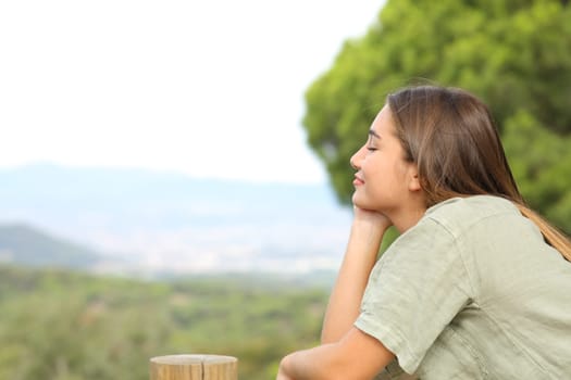 Profile of a happy teen relaxing mind in the mountain