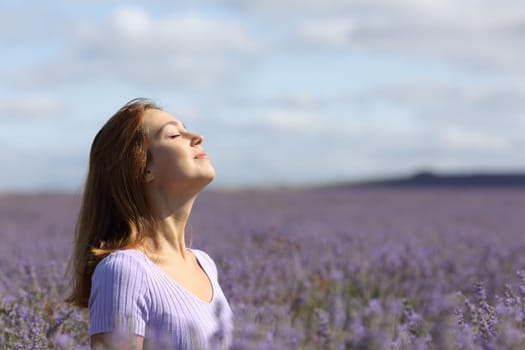 Profile of a beauty woman breathing fresh air in a lavender field