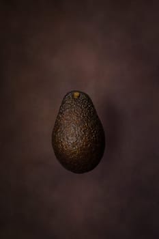 Fresh avocado on dark background. Vegetarian food concept.