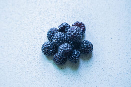 BlackBerry berries stacked in a pyramid on a light background. High quality photo