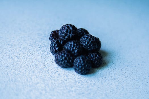 BlackBerry berries stacked in a pyramid on a light background. High quality photo