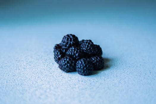BlackBerry berries stacked in a pyramid on a light background. High quality photo