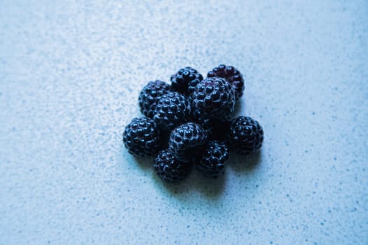 BlackBerry berries stacked in a pyramid on a light background. High quality photo