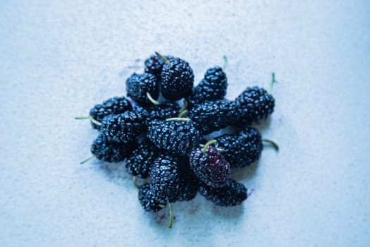 Mulberries or berries of the mulberry tree on a light surface. High quality photo