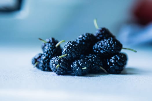 Mulberries or berries of the mulberry tree on a light surface. High quality photo