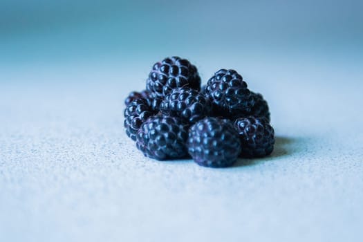 BlackBerry berries stacked in a pyramid on a light background. High quality photo