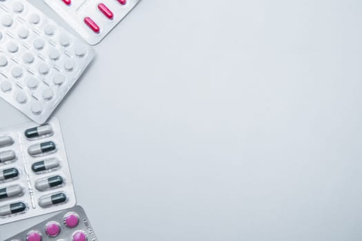 tablets and capsules in the package lie on the side on a white background with a place for text in the middle. High quality photo