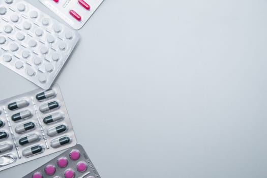 tablets and capsules in the package lie on the side on a white background with a place for text in the middle. High quality photo