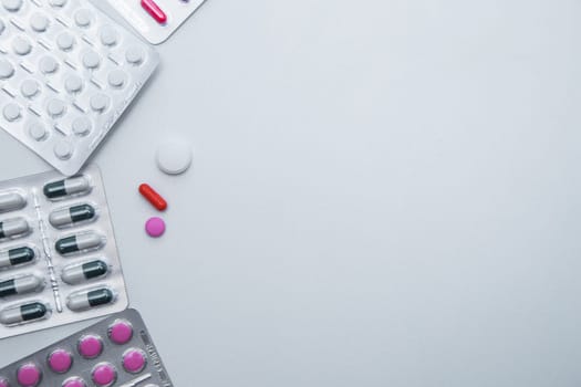 tablets and capsules in the package lie on the side with a handful of tablets on a white background with a place for text in the middle. High quality photo