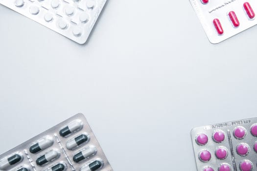 tablets and capsules in the package are in the four corners of the photo with a place for the text in the middle. . High quality photo