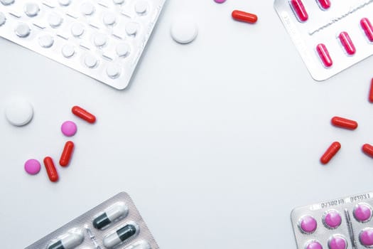 Packages and tablets are on the sides of photos with handfuls of tablets and capsules on the sides on a white background with a place for text in the middle. High quality photo