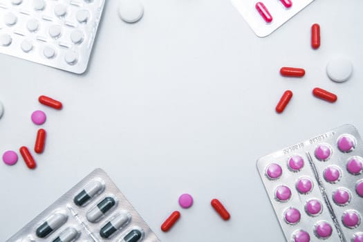 Packages and tablets are on the sides of photos with handfuls of tablets and capsules on the sides on a white background with a place for text in the middle. High quality photo
