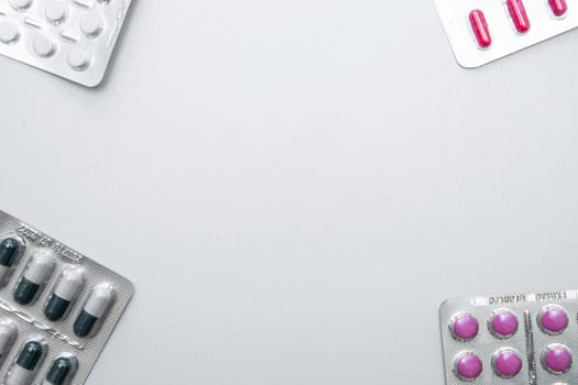tablets and capsules in the package are in the four corners of the photo with a place for the text in the middle. . High quality photo