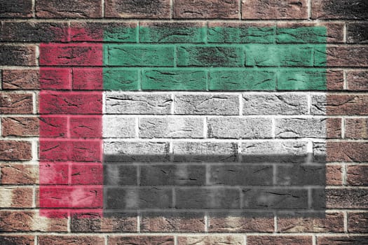 A United Arab Emirates flag on a brick wall background