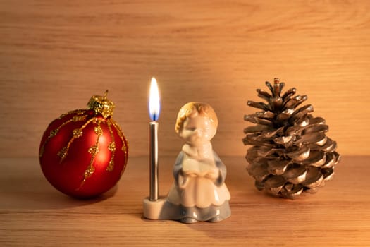Christmas concept with altar boy candle holder, bauble and pine cone close up