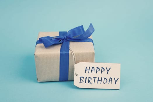 Gift box on a blue colored background, tag with fathers day