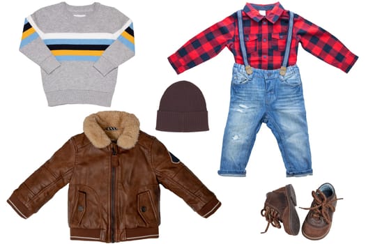 Collage set of little boy autumn clothing isolated on a white background. Denim trouser with plaid shirt, a pair shoes, a leather jacket and pullover or sweater for child boy. Kids winter fashion.