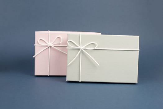Gift boxes in different sizes and colors in front of a dark blue background, copy space