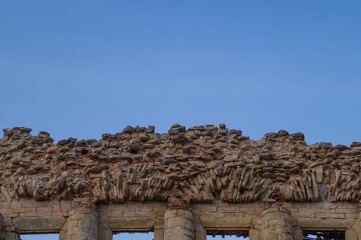 Wall of old ruined building with the sky. windows in ancient brick wall