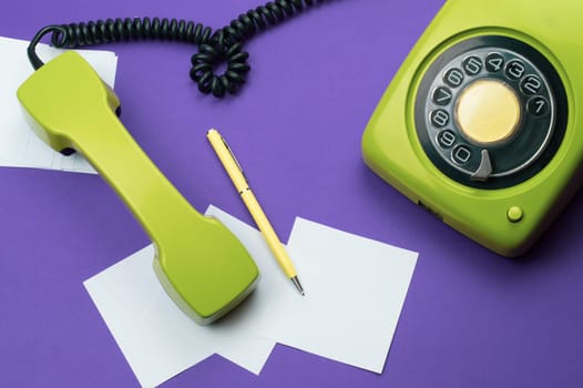 Classic phone with handset. pen with a note. office background. vintage green telephone with phone receiver. old communication technology. copy space
