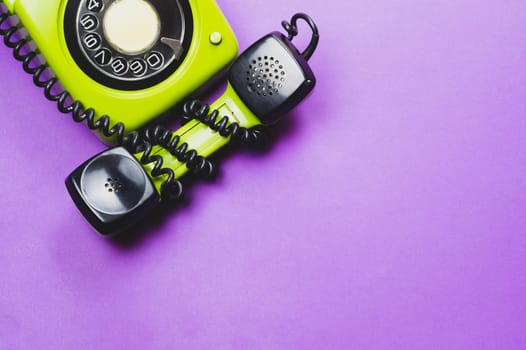 Classic phone with handset. vintage green telephone with phone receiver isolated on purple background. old communication technology. copy space