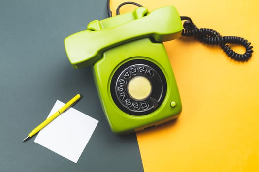 Classic phone with handset. pen with a note. office background. vintage green telephone with phone receiver. old communication technology. copy space