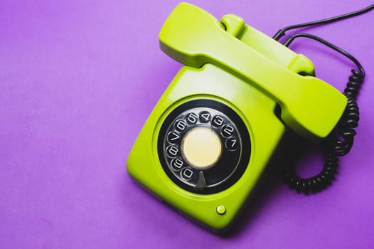 Classic phone with handset. vintage green telephone with phone receiver isolated on purple background. old communication technology. copy space