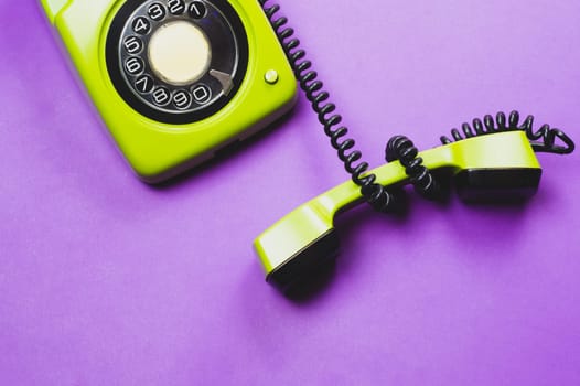 Classic phone with handset. vintage green telephone with phone receiver isolated on purple background. old communication technology. copy space