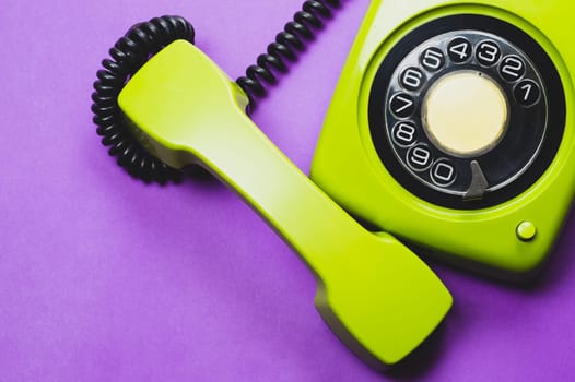 Classic phone with handset. vintage green telephone with phone receiver isolated on purple background. old communication technology. copy space
