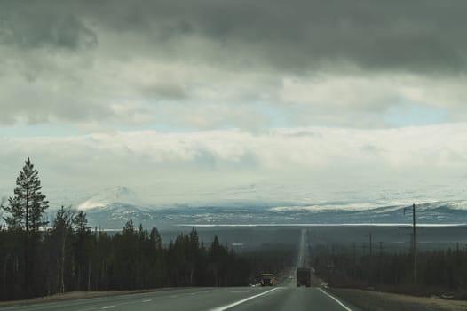 Beautiful mountain landscape with long roadway. winter highway. car driving on a mountain road. horizon line