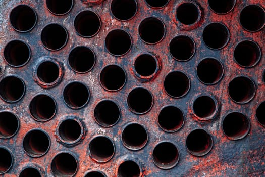 Old and worn industrial metal plate with exhaust ports.