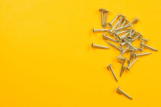 Metal nails isolated on yellow background