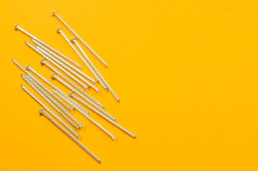 Metal nails isolated on yellow background