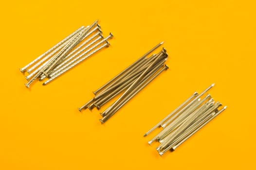Metal nails isolated on yellow background