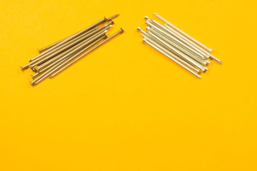Metal nails isolated on yellow background