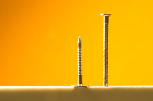 Metal nails isolated on yellow background