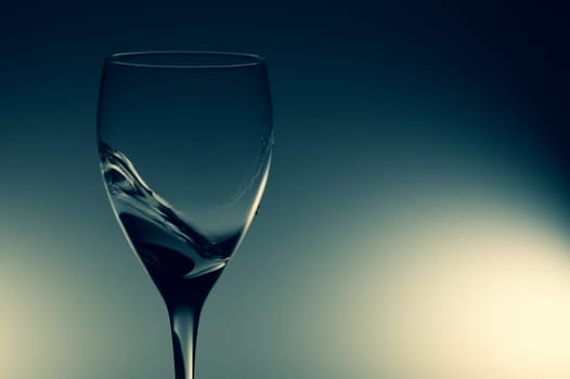 Water splash in glass on glowing background. splashing water in wine glass. transparent cocktail