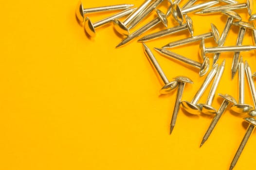 Metal nails isolated on yellow background