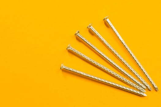 Metal nails isolated on yellow background