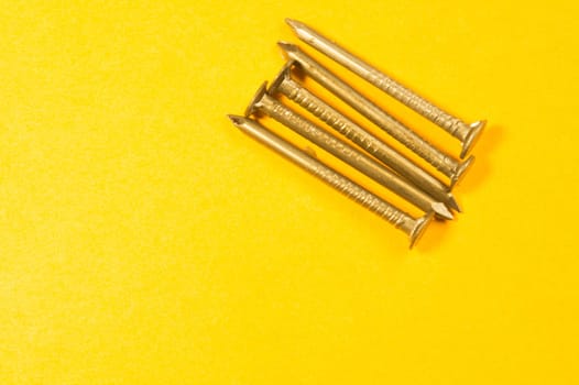 Metal nails isolated on yellow background