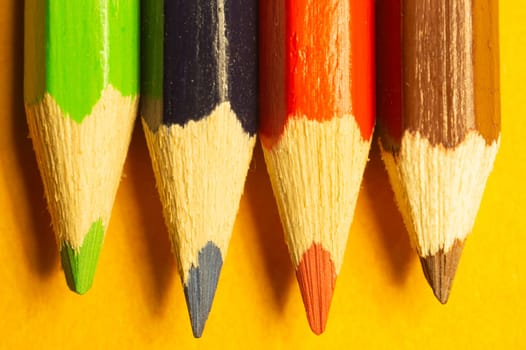 Colorful pencils isolated on yellow background. drawing supplies