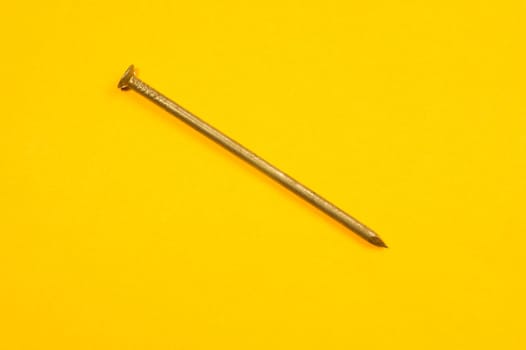 Metal nails isolated on yellow background