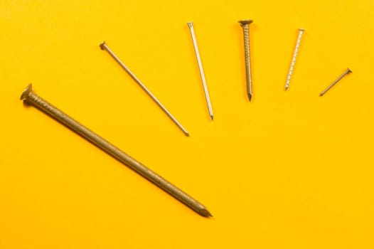 Metal nails isolated on yellow background