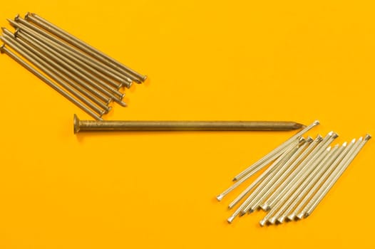 Metal nails isolated on yellow background