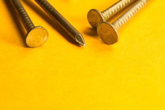 Metal nails isolated on yellow background