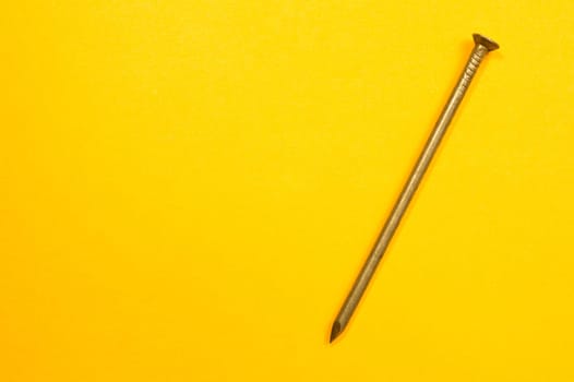 Metal nails isolated on yellow background