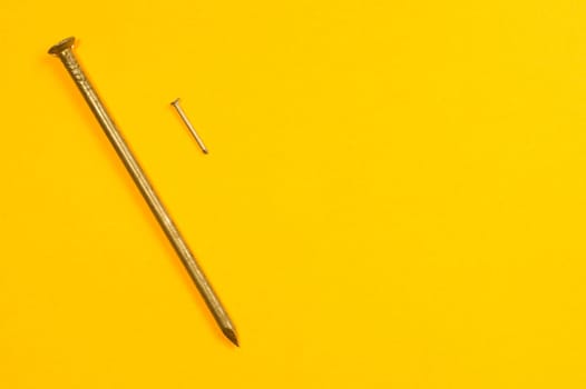 Metal nails isolated on yellow background
